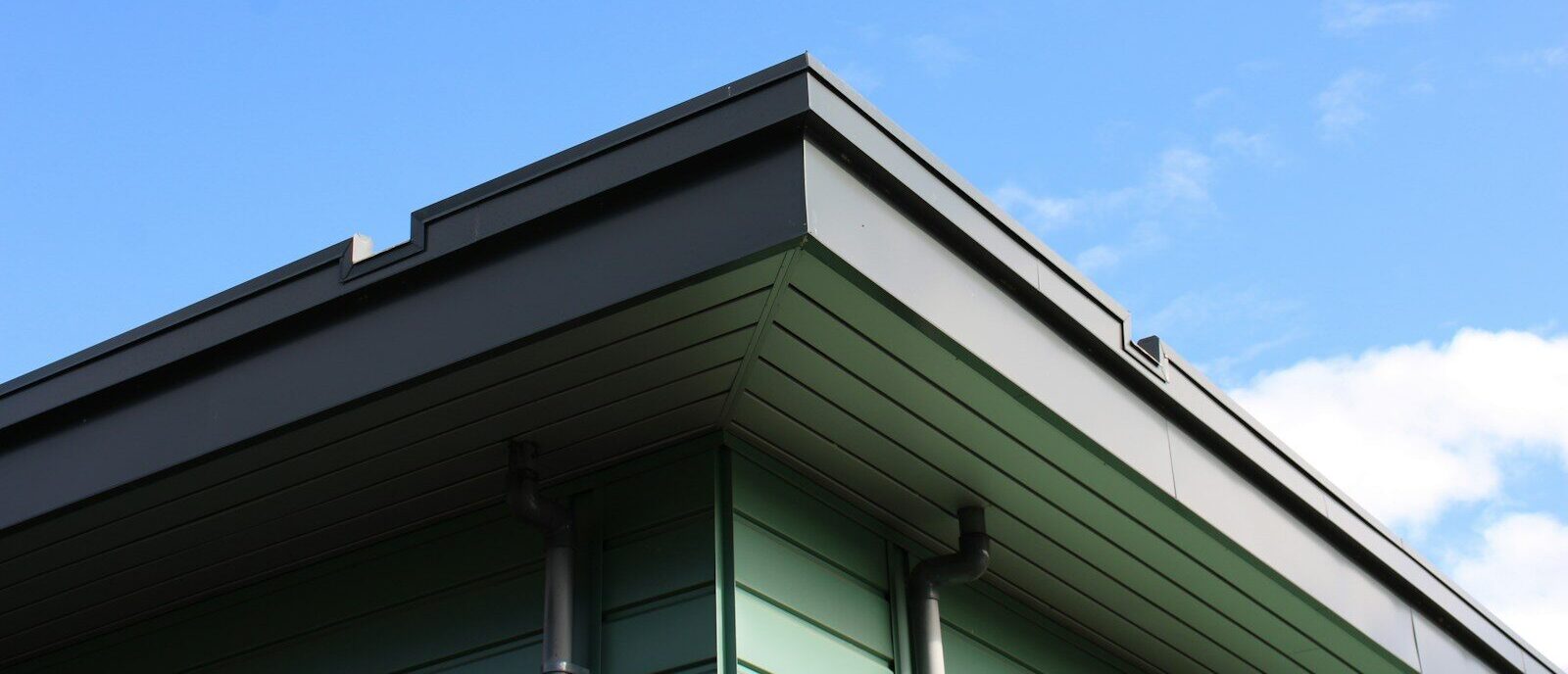 Modern building corner against a bright blue sky